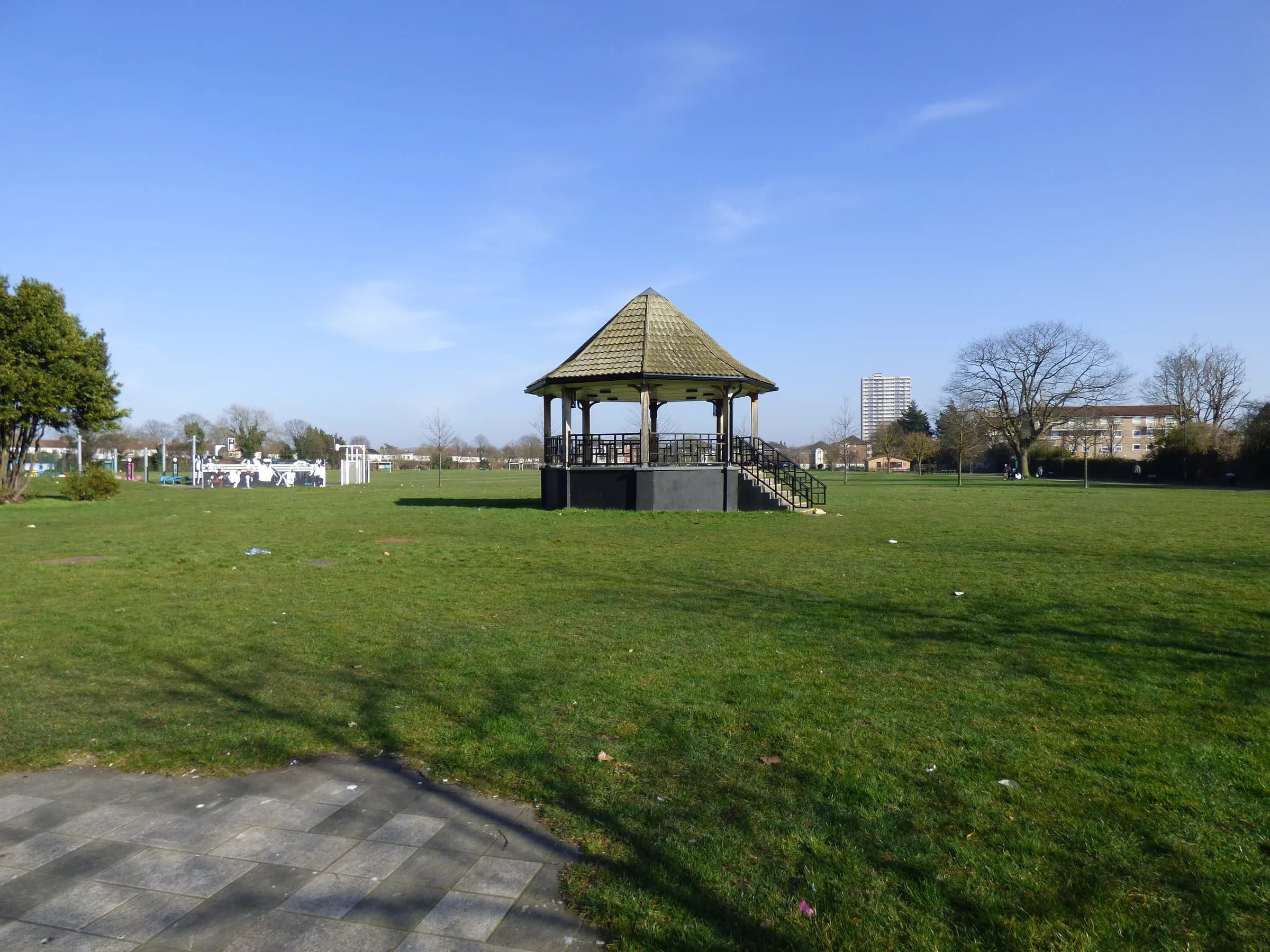 The bandstand on the grass in Ponders End Park under a blue sky