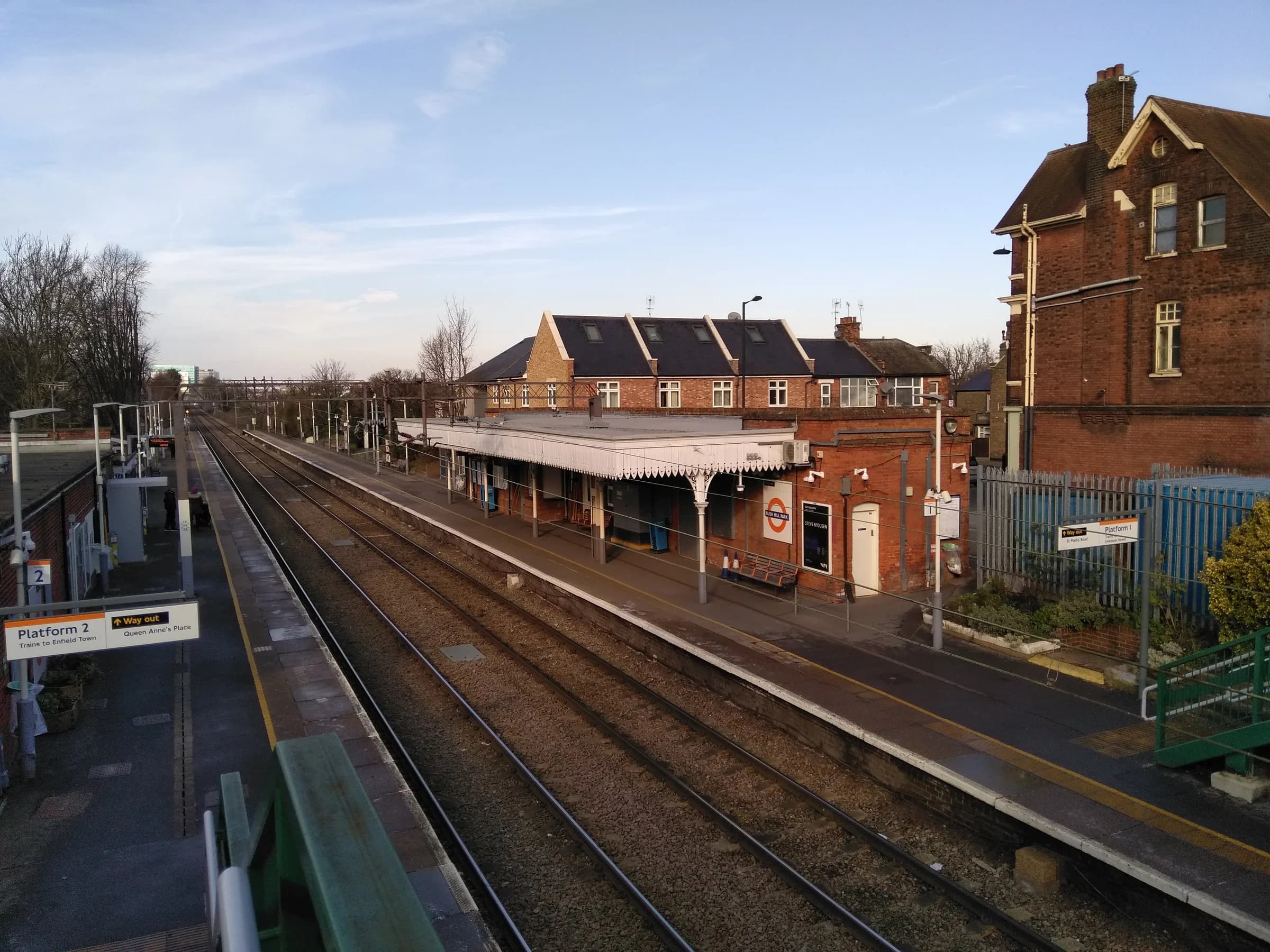 Bush Hill Park railway station seen from the platform, with its brick station building and canopy
