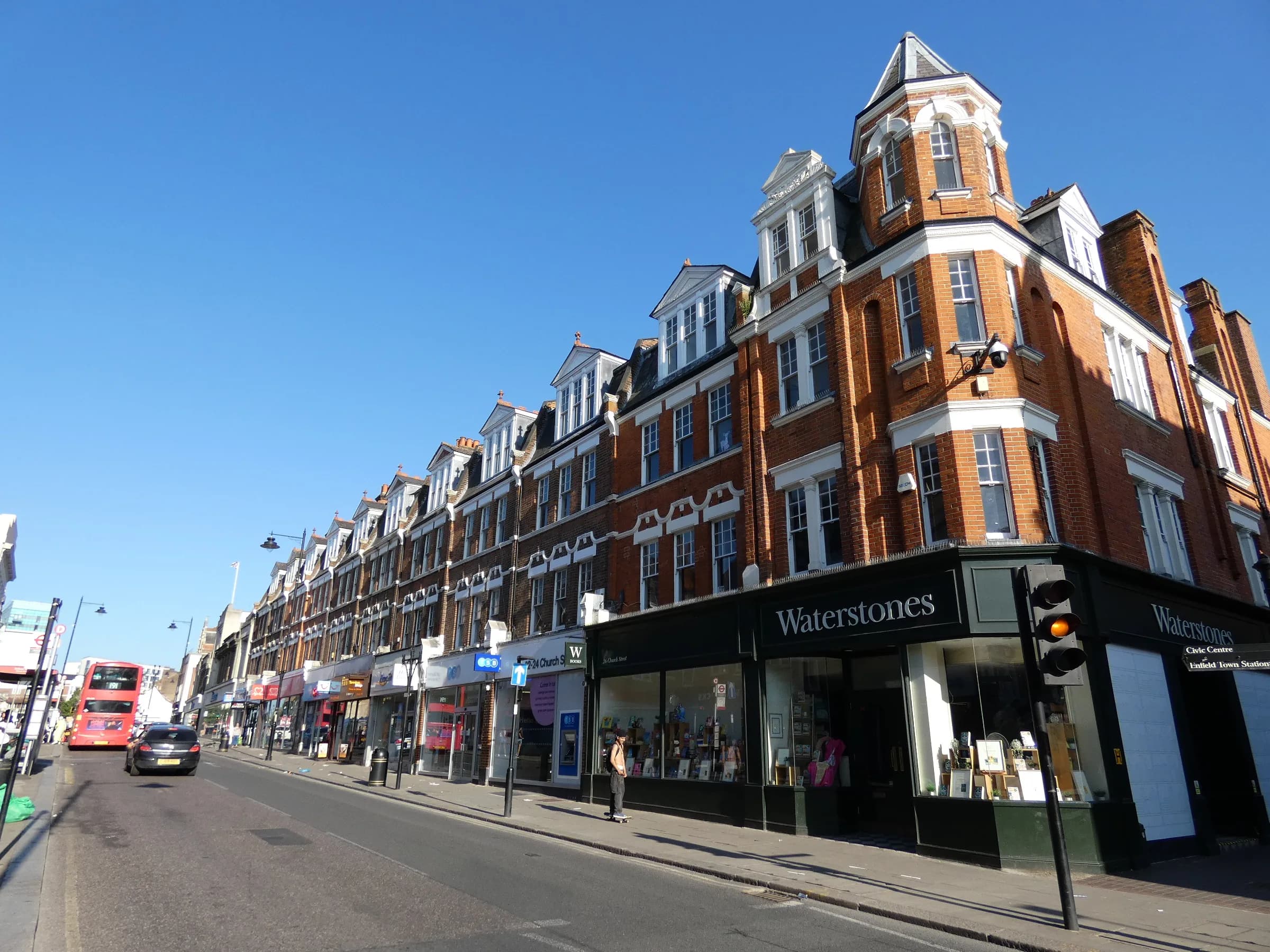 Church Street in Enfield Town, a parade of red-brick Victorian buildings under a blue sky