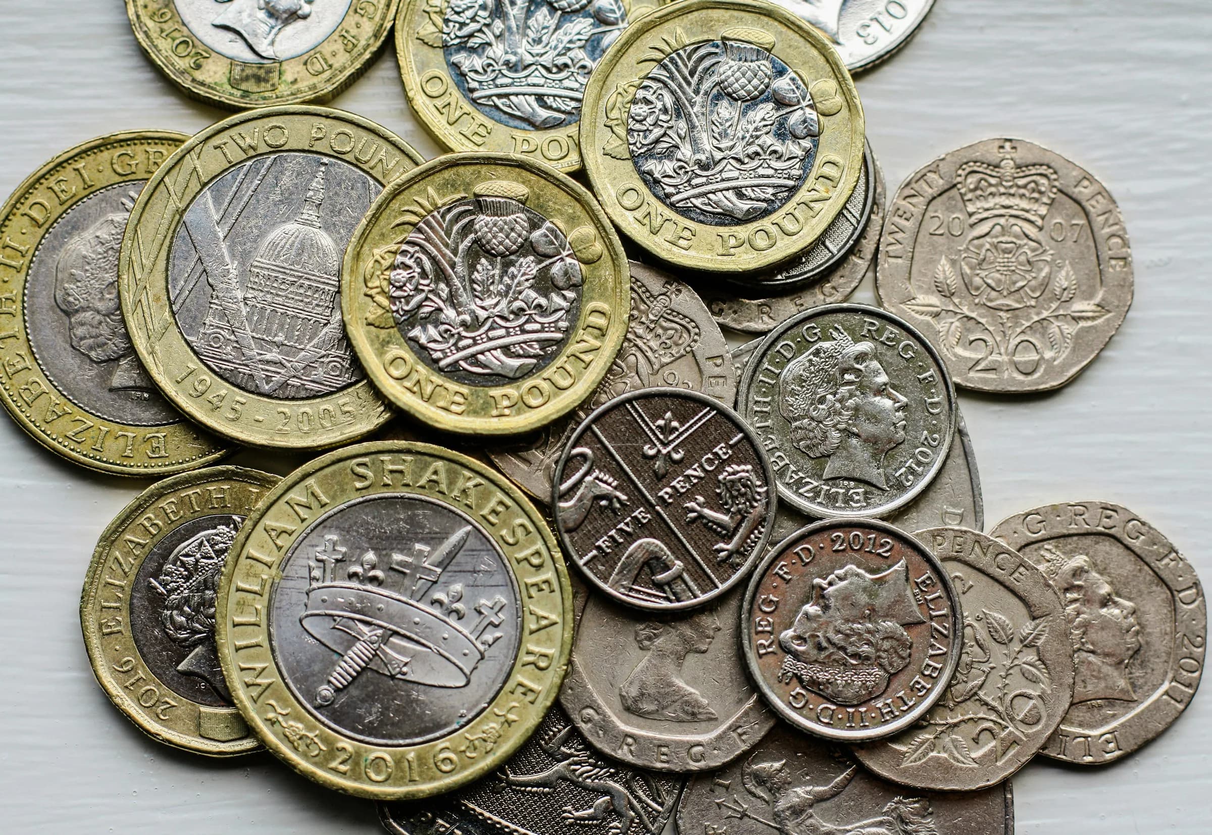 A pile of British pound coins on a table