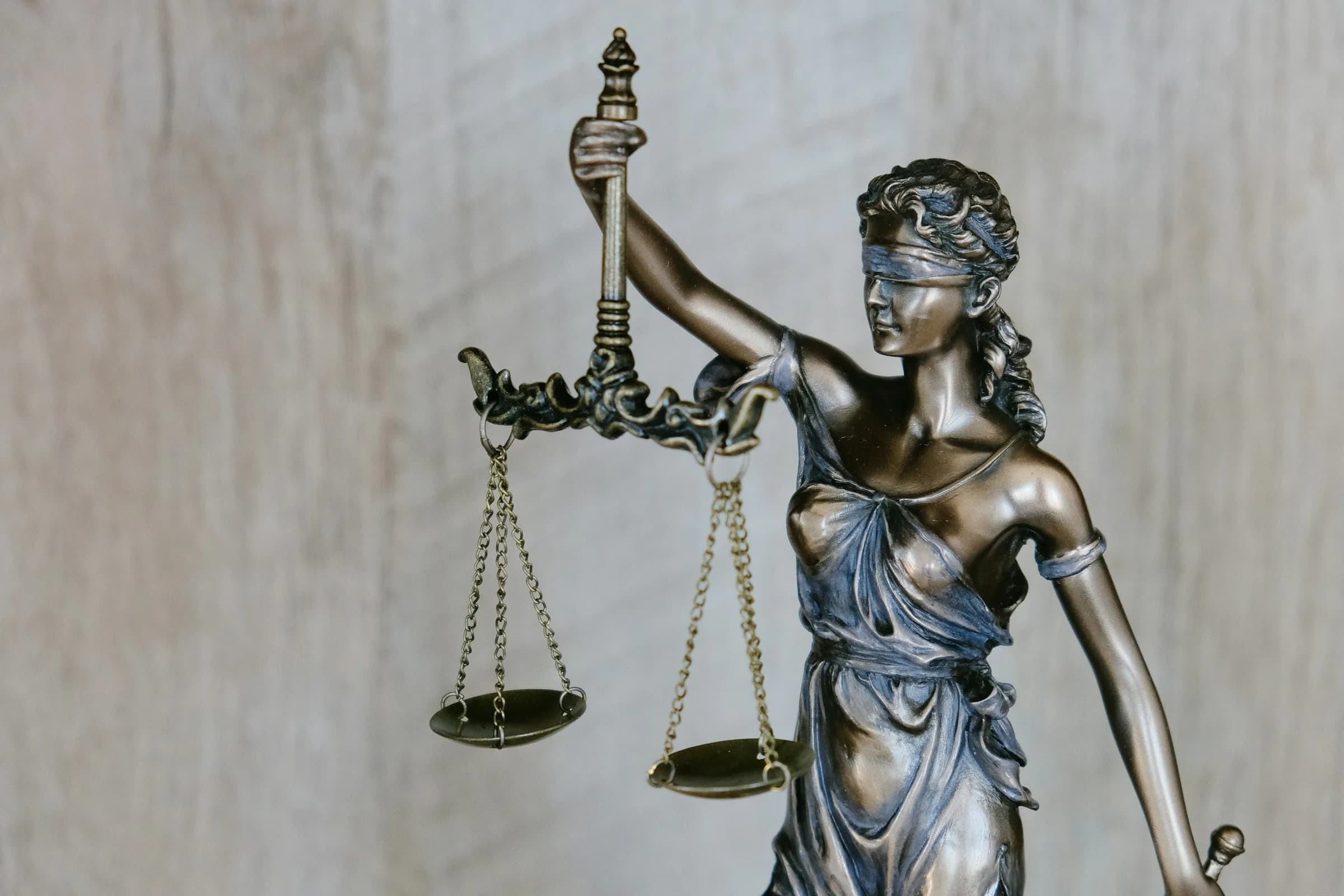 A bronze statue of Lady Justice holding up a pair of scales